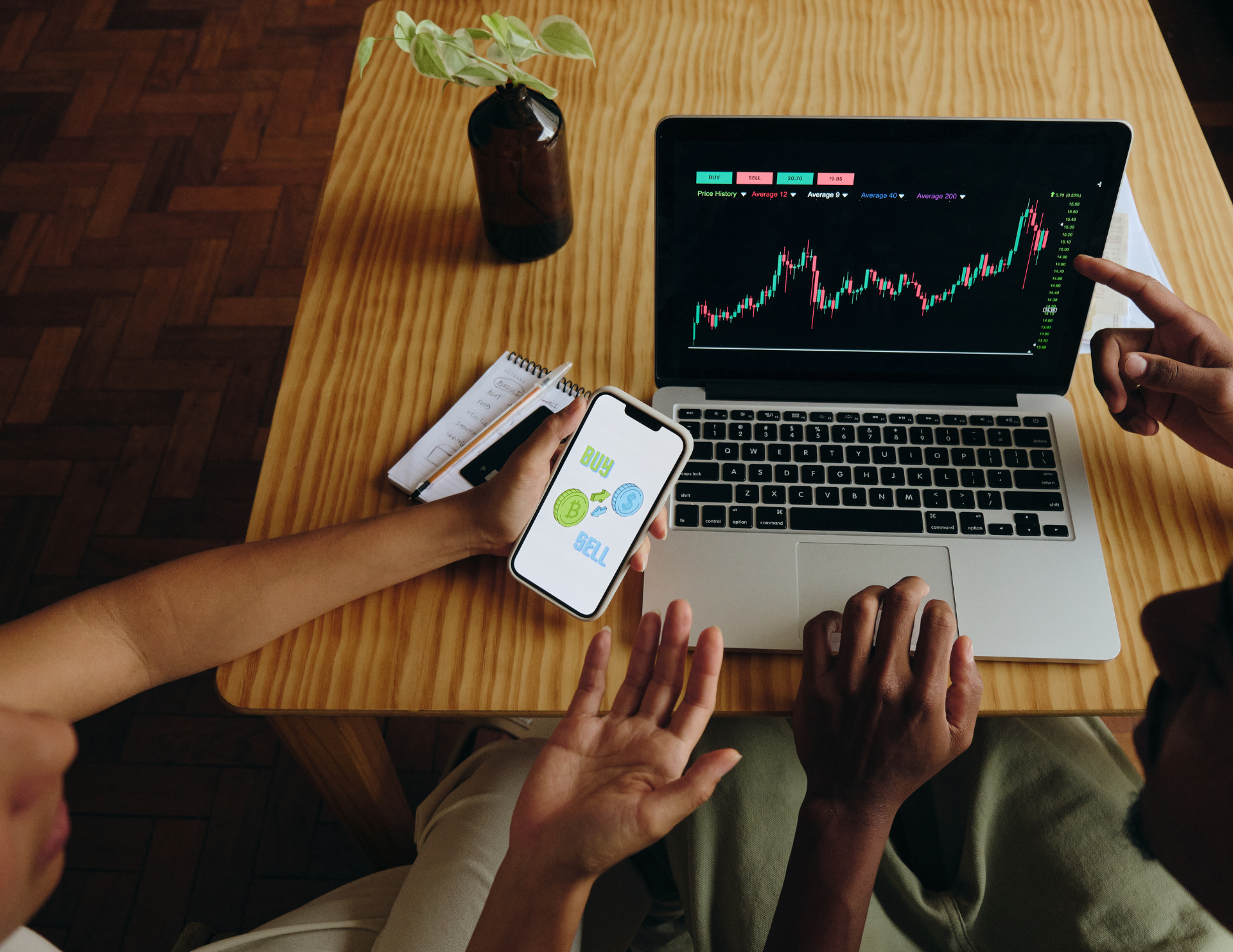 Phone and laptop displaying financial charts and graphs.